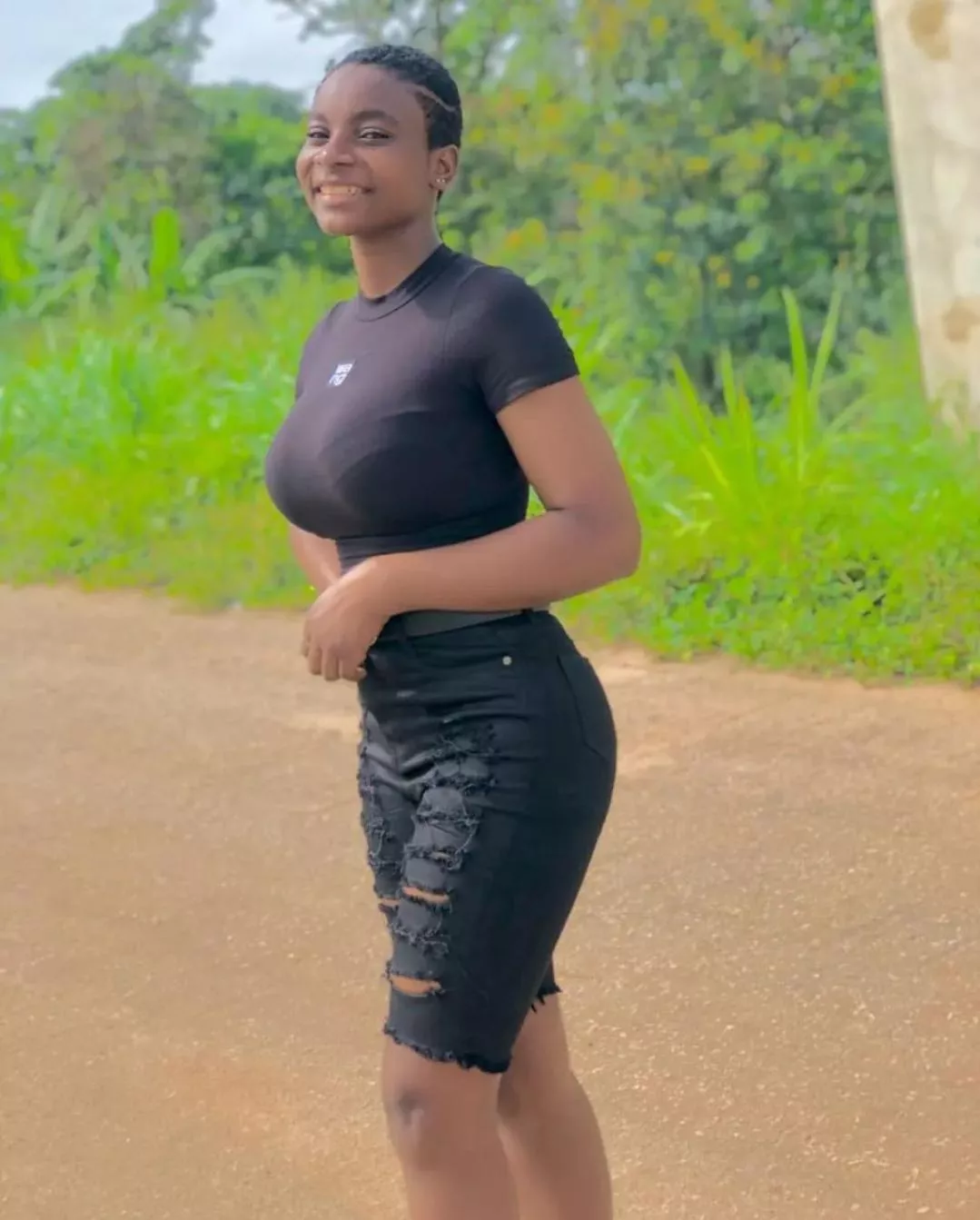 Short-haired black woman posted by Desecr8or