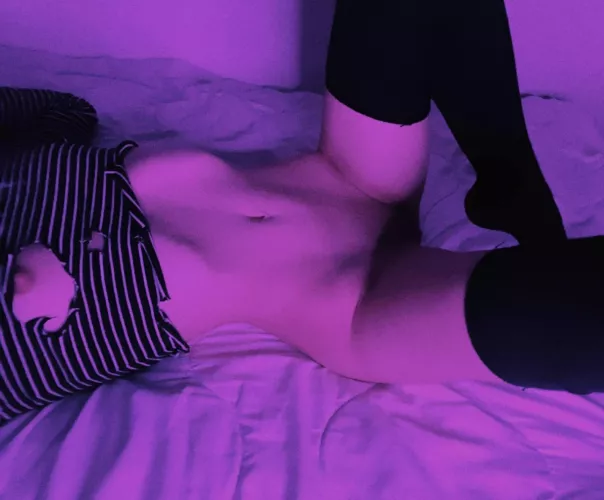 The purple light and tattered sweatshirt highlight the curves of my body by DecayTattoo