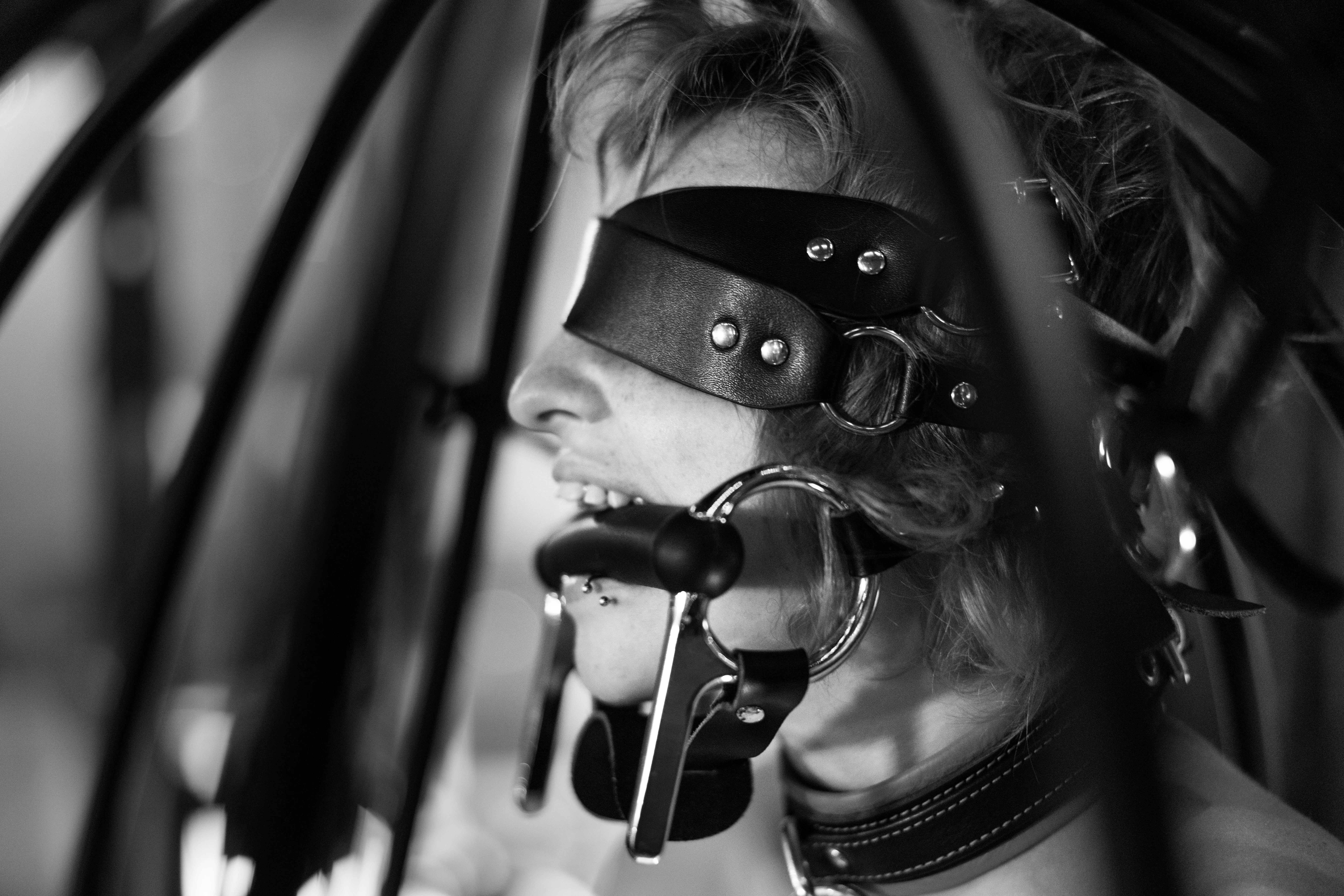 Genesis Fae bit gagged, collared, and blindfolded in a hanging cage, photo by Me posted by CinematicKink