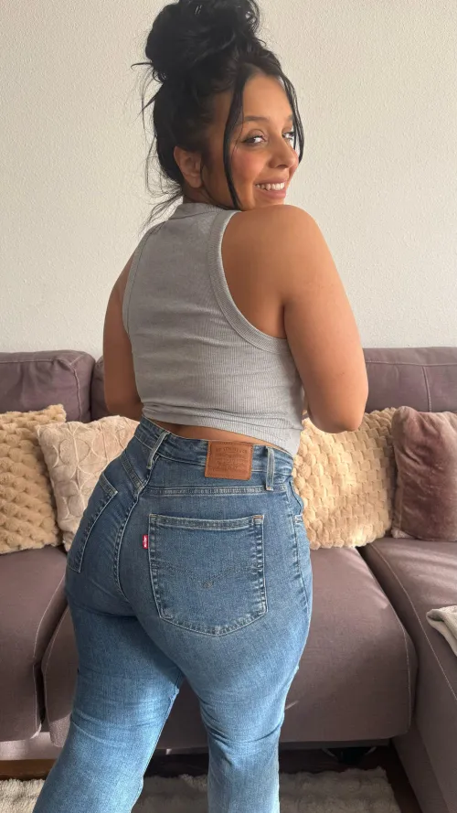 Bronzed curves in snug denim igniting sassy warmth ruling the shore with fiery allure by Galadriel69_