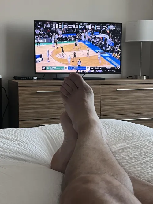 Dad (47) relaxing in my hotel room before my conference starts, and enjoying the start to the NCAA tourney. Would be extra nice if someone was rubbing my feet right now. by RubDadsFeet