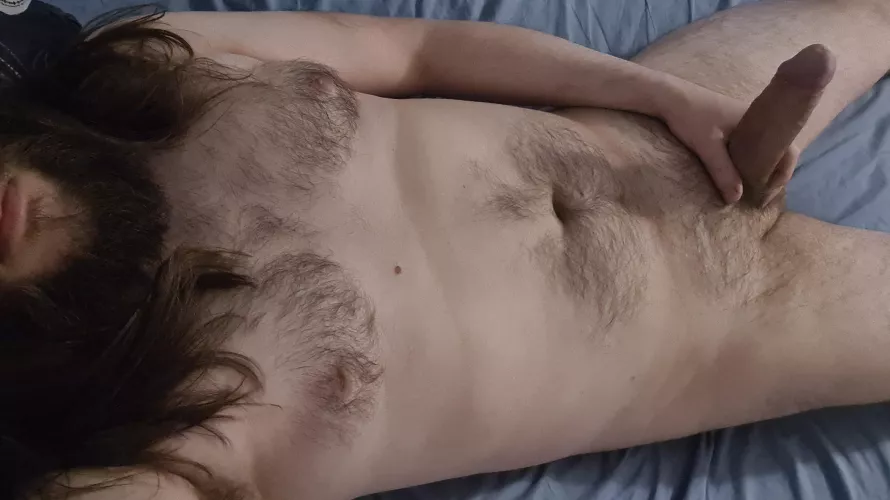 Bearded guy laying down with erect cock pointing upwards