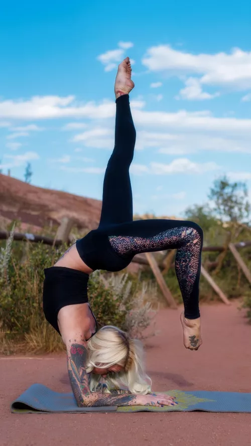 Blonde yoga girl Brittany with tattoos and legs for days. One legged wheel pose. by YogaPhotographer